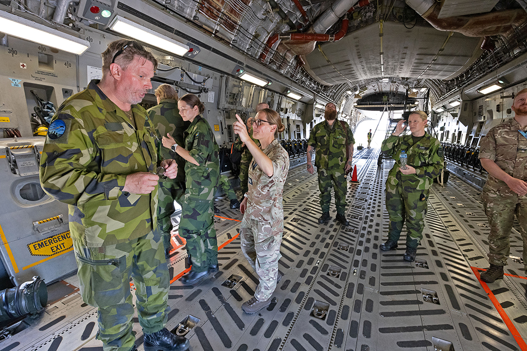 Members of the Swedish Airforce are shown around the voluminous cargo bay of an RAF Globemaster (C-17) by their RAF hosts, who explain objects and answer their questions.